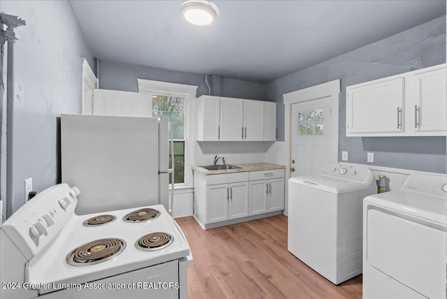 clothes washing area featuring washer and dryer, sink, and light wood-type flooring