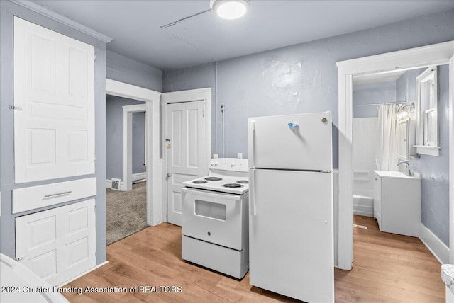 kitchen with light hardwood / wood-style floors, sink, and white appliances