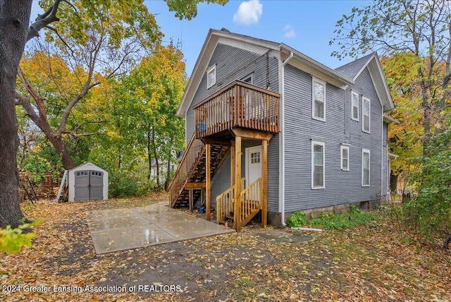 back of house featuring a wooden deck and a storage unit