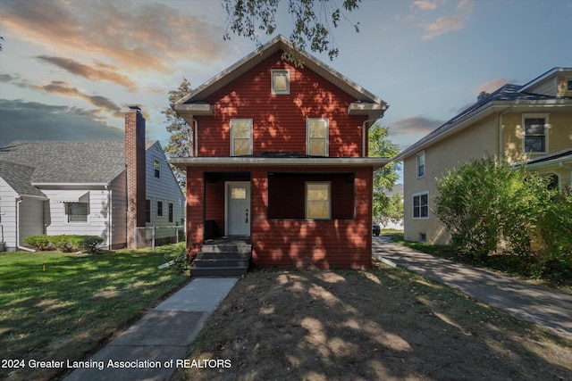 front of property with a lawn and a porch