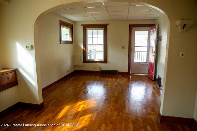 interior space featuring dark hardwood / wood-style flooring and a drop ceiling