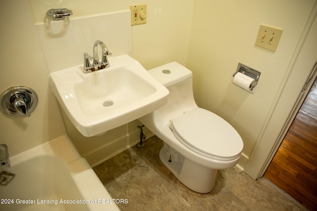 bathroom with a bath, toilet, and sink