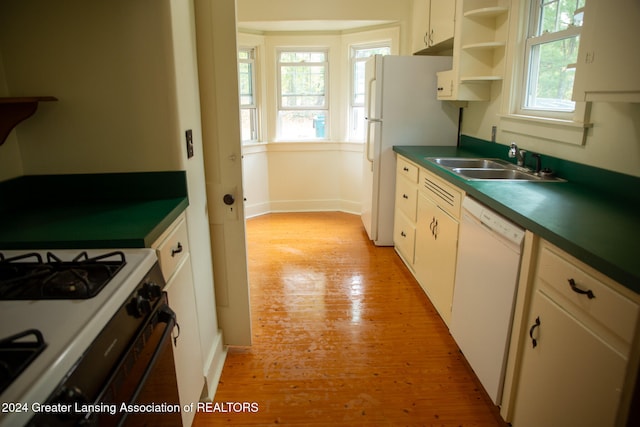 kitchen with white appliances, white cabinetry, sink, and light hardwood / wood-style floors