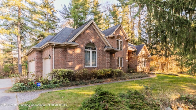 4710 Wellington Dr, Okemos, MI 48864 - view of side of property featuring brick siding, a yard, driveway, a garage, and roof with shingles