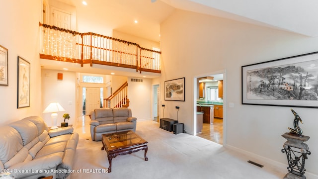 carpeted living room with a high ceiling