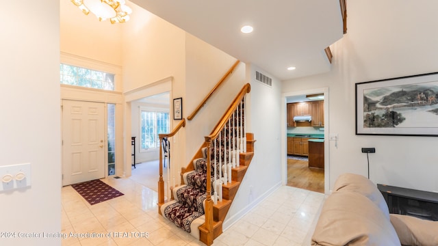 tiled foyer featuring a towering ceiling