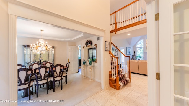 dining space with a chandelier, light colored carpet, and a raised ceiling