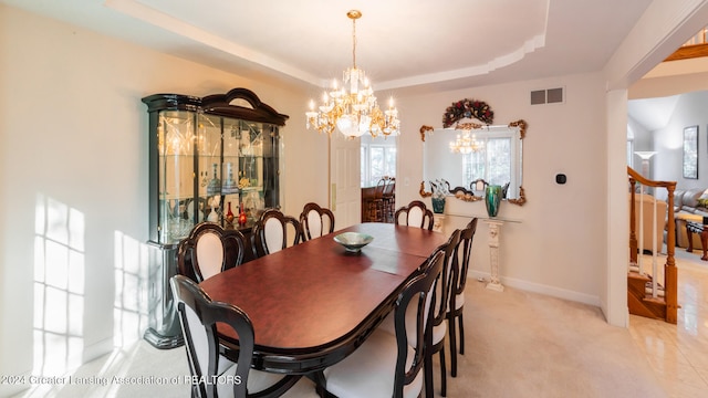 dining space featuring a raised ceiling and a notable chandelier