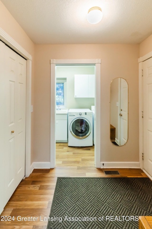 laundry area featuring a textured ceiling and wood-type flooring