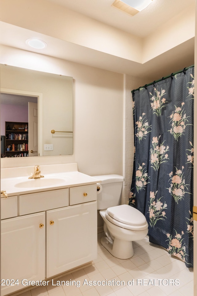 bathroom featuring toilet, vanity, and tile patterned flooring