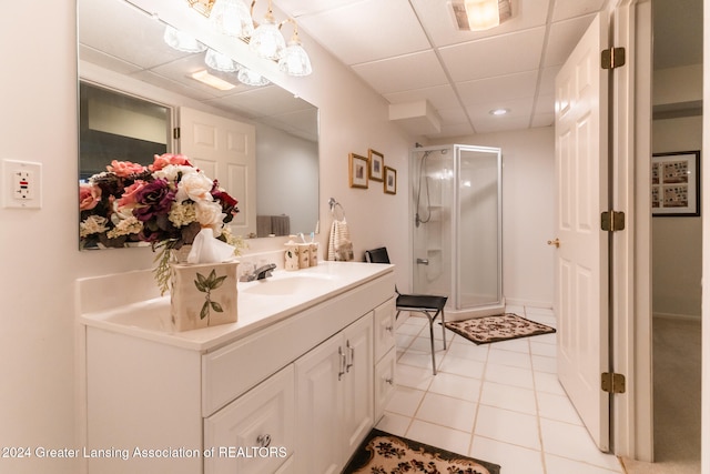 bathroom featuring vanity, tile patterned flooring, a drop ceiling, and a shower with door