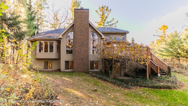4710 Wellington Dr, Okemos, MI 48864 - back of property with a chimney, a deck, a lawn, and stairway