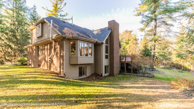 4710 Wellington Dr, Okemos, MI 48864 - back of property featuring a chimney, a lawn, a wooden deck, and a shingled roof