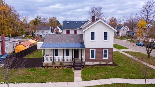 view of front facade featuring a front yard and covered porch