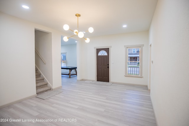 entryway featuring light hardwood / wood-style flooring and a notable chandelier