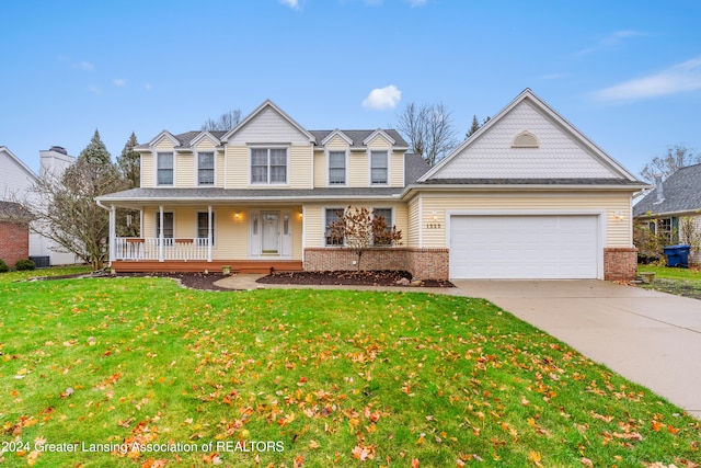 view of front of house featuring covered porch, a garage, and a front lawn