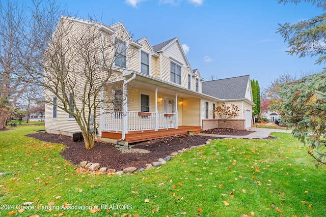 view of front of house featuring a front lawn, covered porch, and a garage