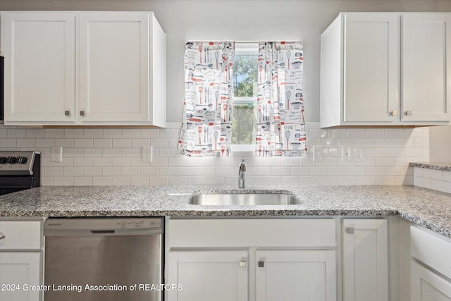 kitchen with light stone countertops, stainless steel appliances, white cabinetry, and sink