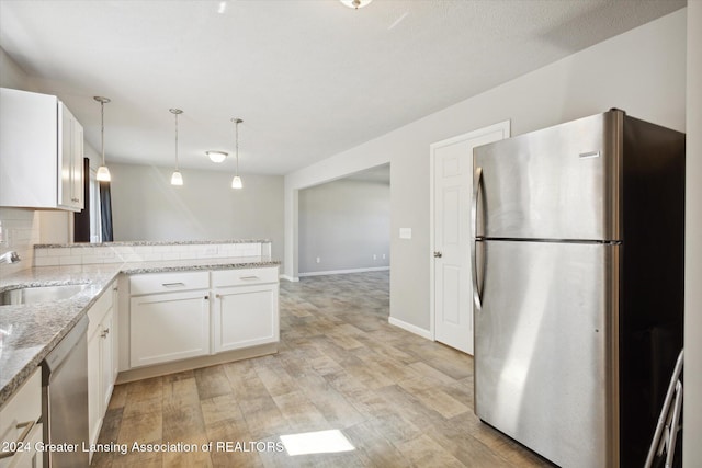 kitchen with kitchen peninsula, stainless steel appliances, light hardwood / wood-style flooring, white cabinets, and hanging light fixtures