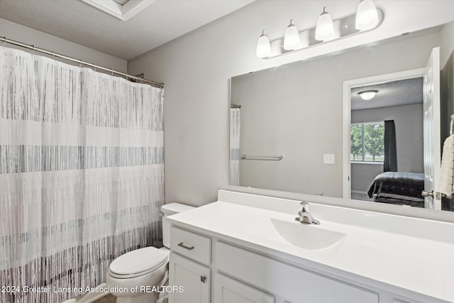 bathroom featuring a shower with curtain, vanity, toilet, and a textured ceiling