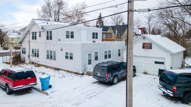 602 N Pennsylvania Ave, Lansing, MI 48912 - view of snowy exterior with a detached garage and an outbuilding
