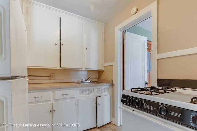 602 N Pennsylvania Ave, Lansing, MI 48912 - kitchen with white gas range oven, light countertops, and white cabinetry