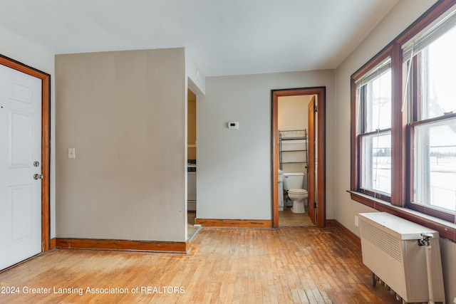 602 N Pennsylvania Ave, Lansing, MI 48912 - unfurnished bedroom with radiator, light wood-type flooring, multiple windows, and ensuite bathroom