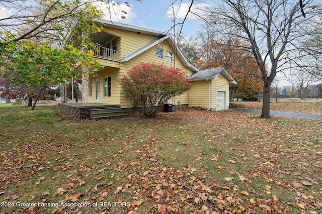 view of side of home featuring a balcony and a yard