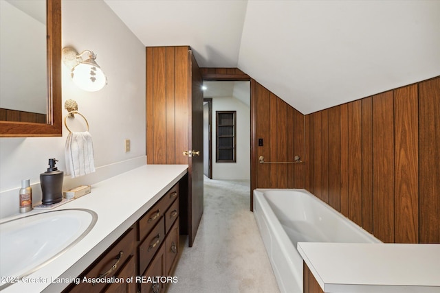 bathroom featuring vanity, wooden walls, a bathtub, and lofted ceiling