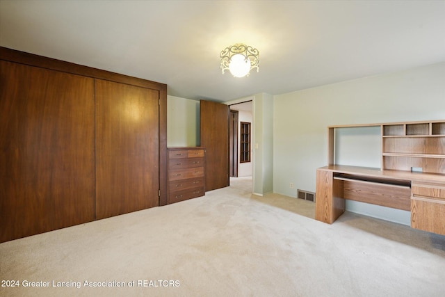 unfurnished bedroom with a closet and light carpet