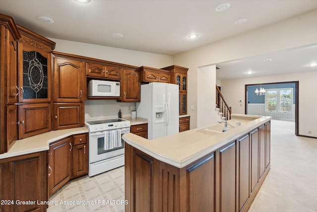 kitchen featuring light carpet, sink, an inviting chandelier, white appliances, and a kitchen island with sink