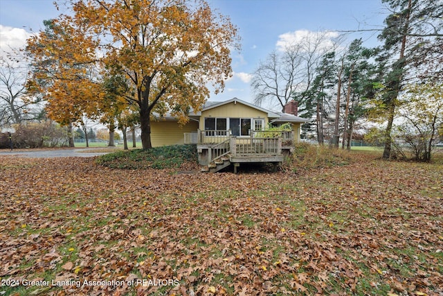 back of property with a sunroom and a wooden deck