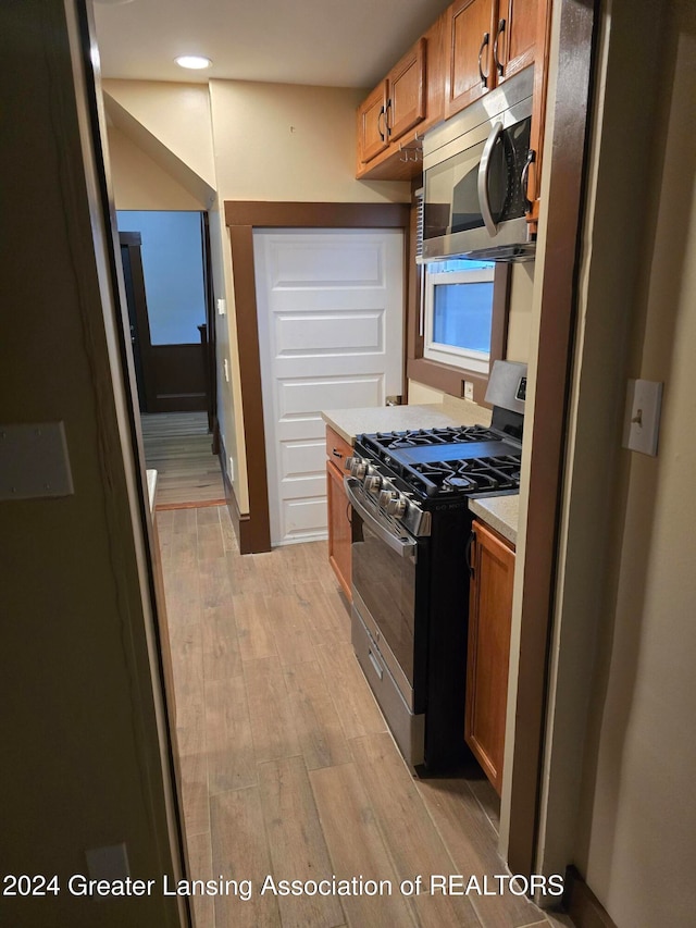 kitchen featuring light wood-type flooring and appliances with stainless steel finishes