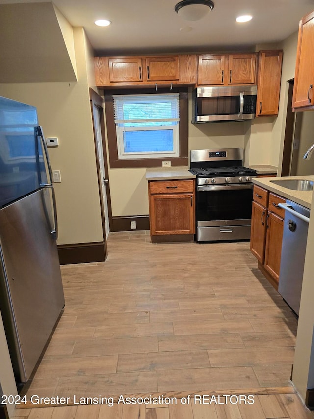 kitchen featuring light wood-type flooring, stainless steel appliances, and sink