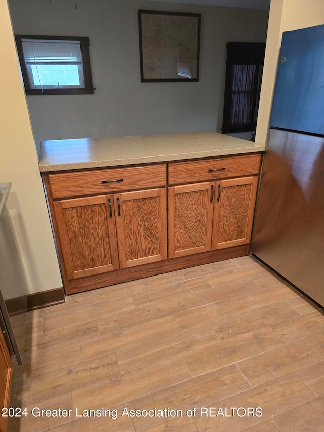 details with stainless steel fridge and hardwood / wood-style floors