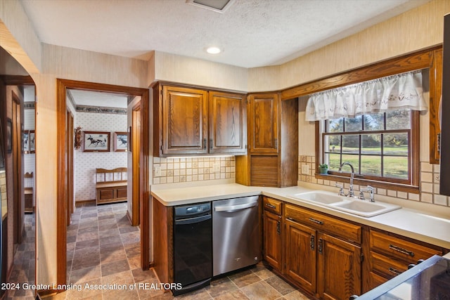 kitchen with decorative backsplash, stainless steel dishwasher, sink, and a textured ceiling