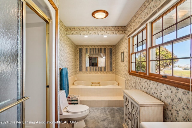 bathroom with a relaxing tiled tub and toilet