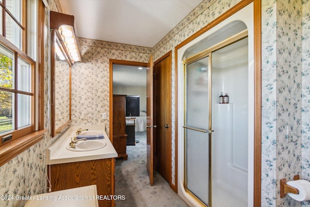 bathroom with walk in shower, vanity, and a healthy amount of sunlight