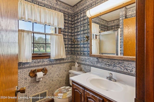 bathroom featuring walk in shower, tile walls, vanity, and toilet