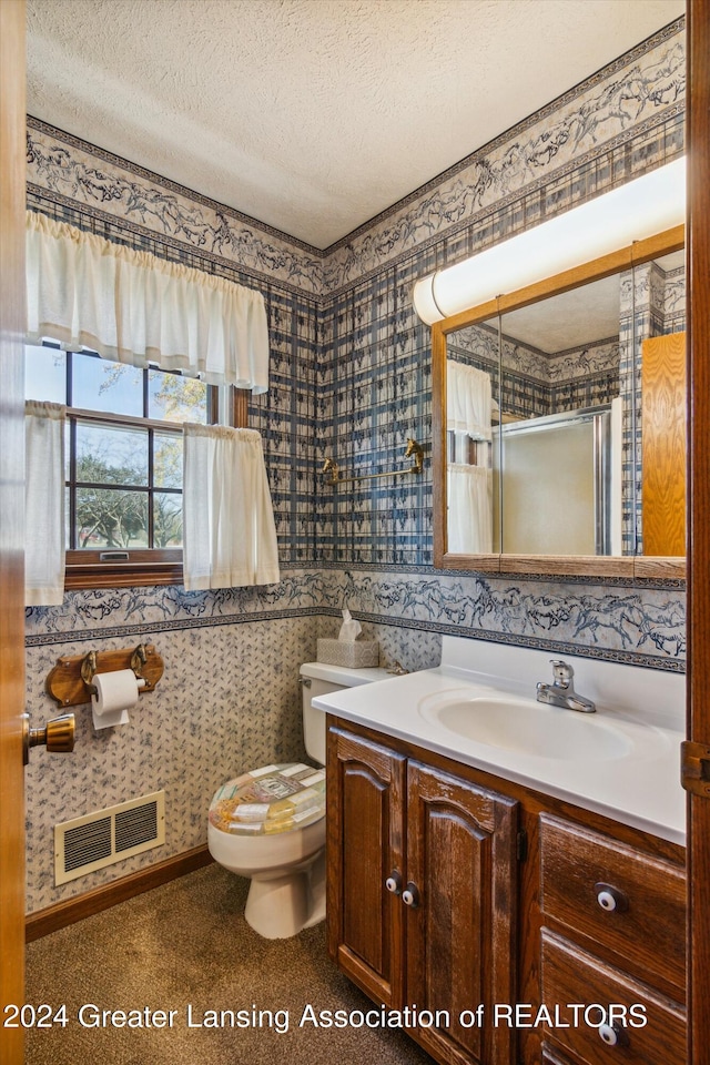 bathroom featuring toilet, an enclosed shower, vanity, and a textured ceiling