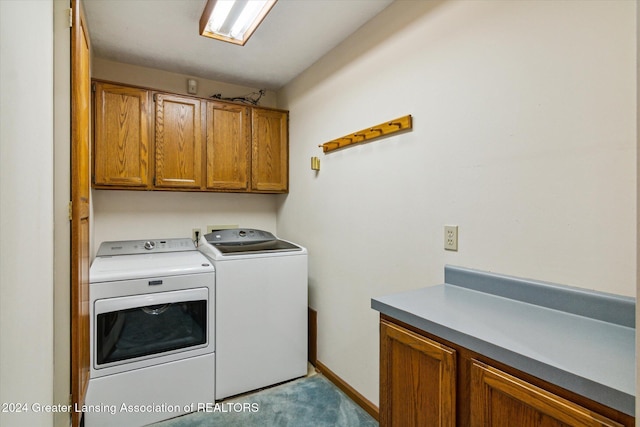 washroom with washing machine and dryer and cabinets