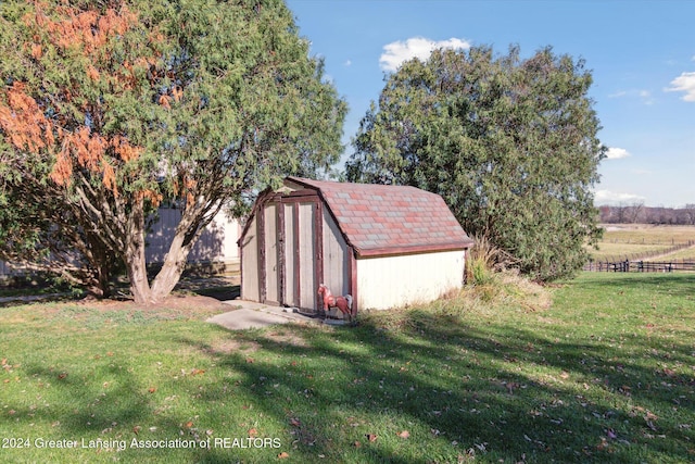 view of outbuilding featuring a lawn and a rural view