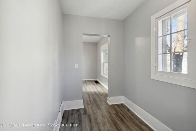 corridor with dark hardwood / wood-style flooring