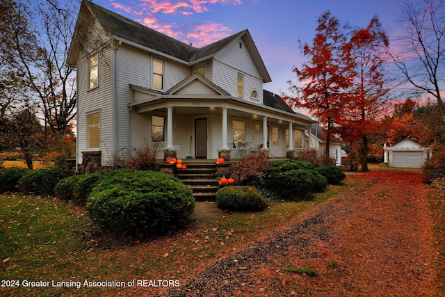 view of front of home featuring a porch and an outdoor structure