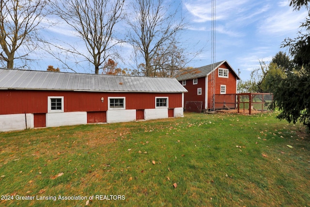 back of house featuring an outdoor structure and a lawn