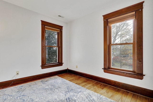 unfurnished room featuring hardwood / wood-style flooring and a wealth of natural light