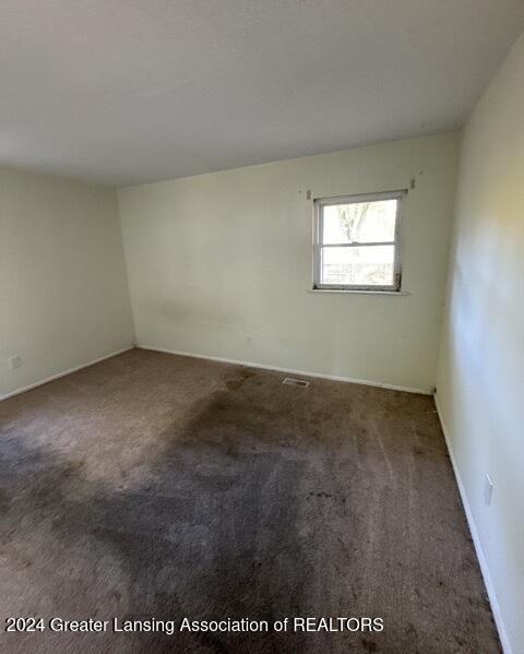 empty room featuring dark colored carpet