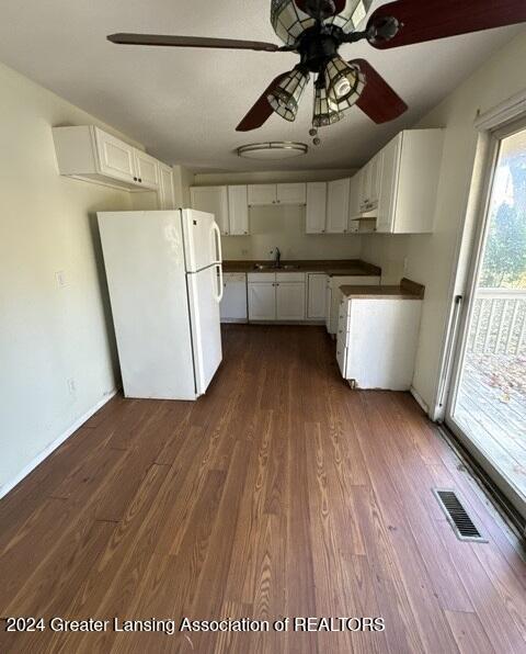 kitchen featuring white cabinets, dark wood-type flooring, ceiling fan, and white fridge