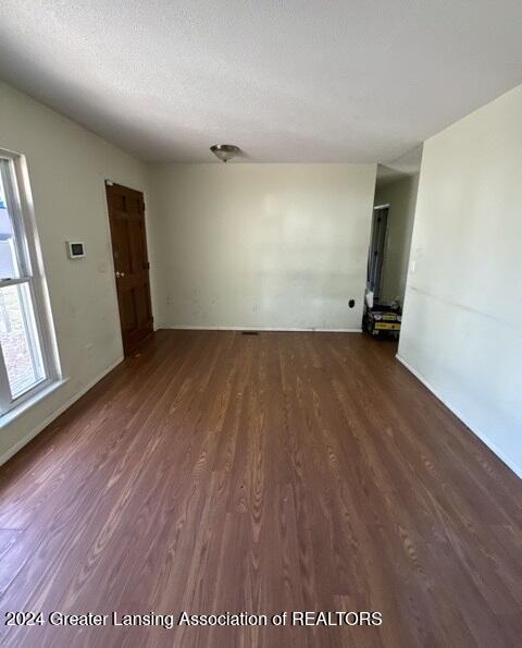 spare room with dark hardwood / wood-style flooring and a textured ceiling