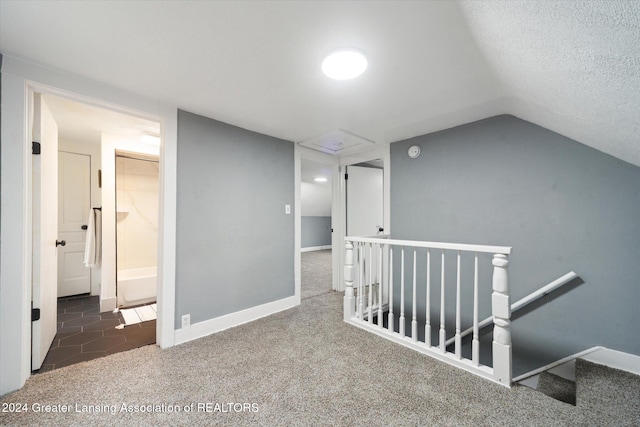 interior space with a textured ceiling and vaulted ceiling